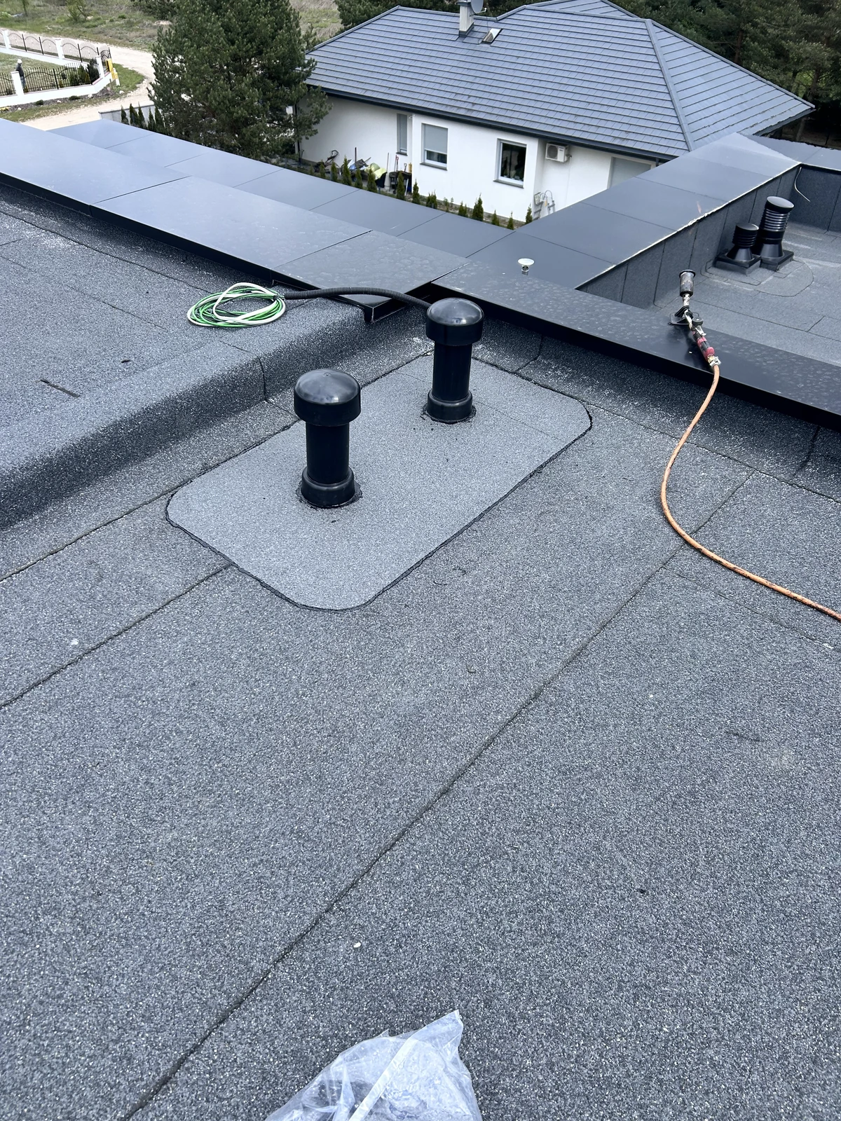 Płaski dach z hydroizolacją dachu i dwoma wywietrznikami wentylacyjnymi